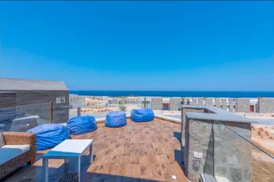 a rooftop deck with blue domed chairs and the ocean at Luxury Stays in Wadi Jebal Soma Bay in Hurghada