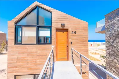 a wooden house with a yellow door on the beach at Luxury Stays in Wadi Jebal Soma Bay in Hurghada