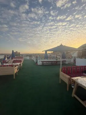 a group of chairs and umbrellas on a lawn at ASKALEIH Nubian Guest House in Aswan