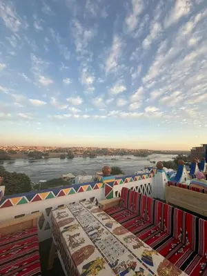 a balcony with tables and a view of a river at ASKALEIH Nubian Guest House in Aswan