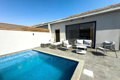 a patio with chairs and a swimming pool at Elegance Serene 3 BDR Townhouse w Private Pool Bali Gouna in Hurghada