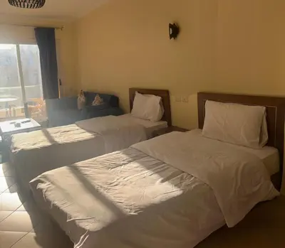 a hotel room with two beds and a couch at Studio Apartment Flourenza Hurghada in Hurghada