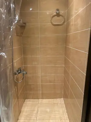 a bathroom with a shower with a tiled floor at Studio Apartment Flourenza Hurghada in Hurghada