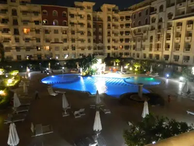 a large pool in front of a building at night at Florenza Khamsin Nor in Hurghada