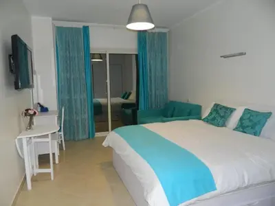 a bedroom with a bed and a couch and a table at Florenza Khamsin Nor in Hurghada