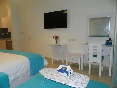 a bedroom with a bed and a desk and a tv at Florenza Khamsin Nor in Hurghada