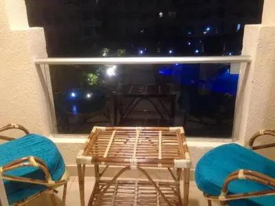 a balcony with two chairs and a table and a window at Florenza Khamsin Nor in Hurghada