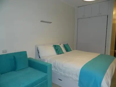a bedroom with a bed and a blue couch at Florenza Khamsin Nor in Hurghada