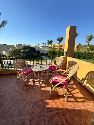 a patio with chairs and a table on a balcony at Stella Makadi Bay - Balcony Apartment near Pool & Beach - Holiday Makadi in Hurghada