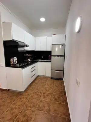 a kitchen with white cabinets and a tile floor at Stella Makadi Bay - Balcony Apartment near Pool & Beach - Holiday Makadi in Hurghada