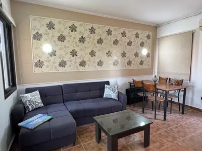 a living room with a couch and a table at Stella Makadi Bay - Balcony Apartment near Pool & Beach - Holiday Makadi in Hurghada