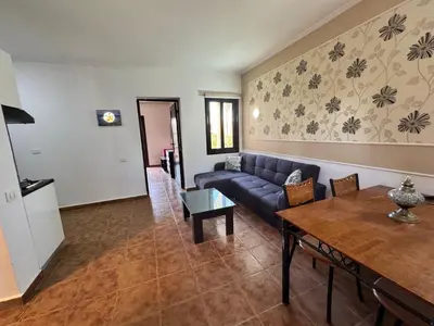 a living room with a blue couch and a table at Stella Makadi Bay - Balcony Apartment near Pool & Beach - Holiday Makadi in Hurghada