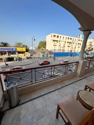 a balcony with a view of a street and a building at La Blanca in Hurghada