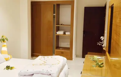 a room with a bed and a wooden cabinet at La Blanca in Hurghada