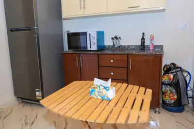 a kitchen with a wooden table and a microwave at Tohamy house in Al Aqālitah