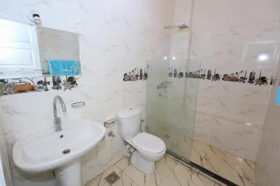 a bathroom with a toilet and a sink and a shower at Tohamy house in Al Aqālitah