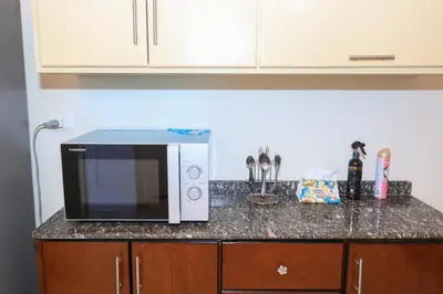 a microwave sitting on a counter in a kitchen at Tohamy house in Al Aqālitah