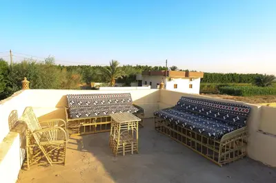a group of chairs and tables on a patio at Tohamy house in Al Aqālitah