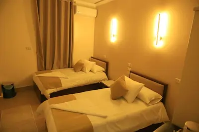 a hotel room with two beds and lights on the wall at Crystala 2 guest house in Aswan