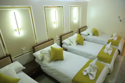 three beds in a hotel room with mirrors at Crystala 2 guest house in Aswan