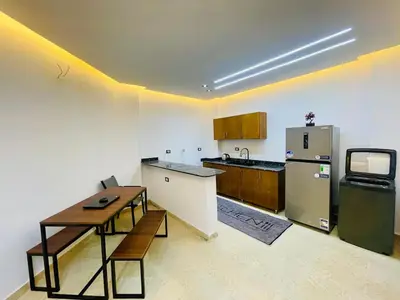 a kitchen with a refrigerator and a table in it at Modern place Hurghada in Hurghada