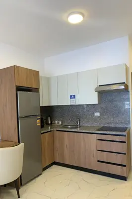 a kitchen with wooden cabinets and a stainless steel refrigerator at Hurghada concierge at La Prestigia B2 4 in Hurghada