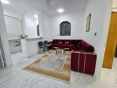 a living room with a red couch and a table at Hatshepsut Apartments Luxor in Luxor