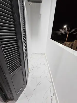 a white room with a window and a marble floor at Hatshepsut Apartments Luxor in Luxor