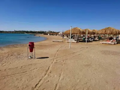 a beach with some chairs and umbrellas and the water at Princess resort217 in Hurghada