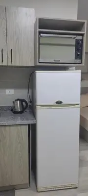 a microwave and a refrigerator in a kitchen at Princess resort217 in Hurghada