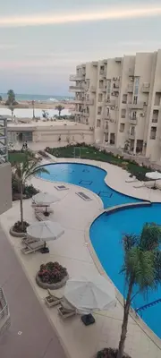 a view of a hotel with two pools and umbrellas at Princess resort217 in Hurghada