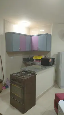 a kitchen with a stove and purple cabinets at Elite House in Hurghada