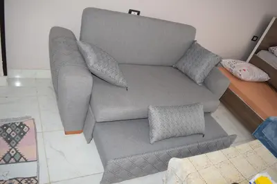 a grey couch with pillows in a living room at Al Mutamayz Tiba in Hurghada