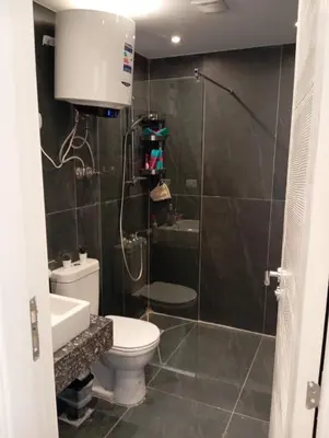 a bathroom with a shower with a toilet and a sink at Bali 2 bed with private pool in Hurghada