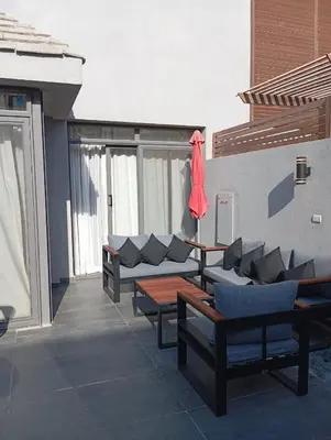 a patio with couches and tables on a building at Bali 2 bed with private pool in Hurghada