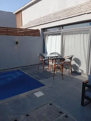 a patio with a table and chairs and a pool at Bali 2 bed with private pool in Hurghada