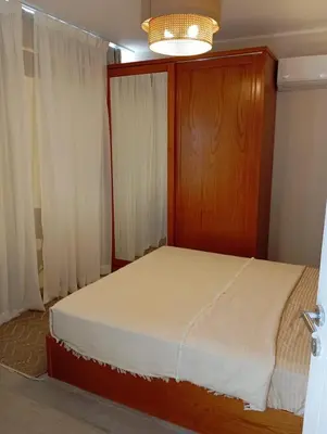 a bedroom with a bed with a wooden headboard and curtains at Bali 2 bed with private pool in Hurghada