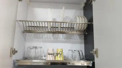 a shelf in a kitchen with dishes and utensils at Stylish Sunny Central 1BR in Hurghada