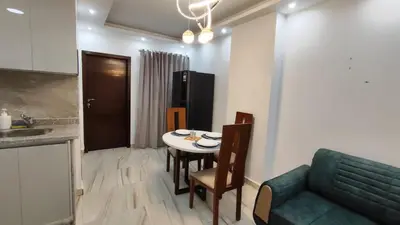 a kitchen and dining room with a table and a couch at Stylish Sunny Central 1BR in Hurghada