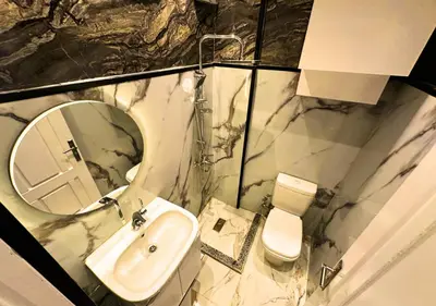 a bathroom with a sink and a mirror and a toilet at Modern Sea View Palma House Steps from Dream Beach in Hurghada
