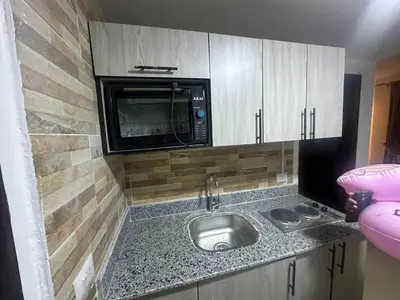 a kitchen with a sink and a microwave at Balkan Resort in Hurghada