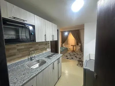 a kitchen with a sink and a microwave at Balkan Resort in Hurghada
