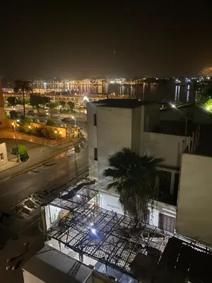a view of a city at night with a building at Tut Apartment in Luxor