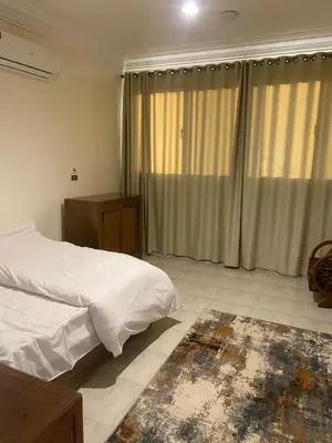 a bedroom with a bed with white sheets and curtains at Tut Apartment in Luxor