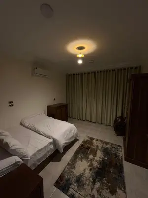 a bedroom with two beds and a rug on the floor at Tut Apartment in Luxor
