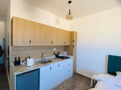 a kitchen with a sink and wooden cabinets at Aqua Infinity in Hurghada