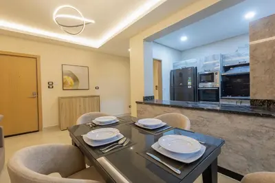 a dining room with a table and chairs and a kitchen at The D9 Luxury Suites - Hurghada in Hurghada