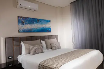 a bedroom with a large white bed with pillows at The D9 Luxury Suites - Hurghada in Hurghada