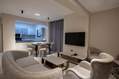 a living room with a tv and a table and chairs at The D9 Luxury Suites - Hurghada in Hurghada