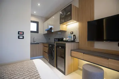 a kitchen with a television and a kitchen with a stove at The D9 Luxury Suites - Hurghada in Hurghada